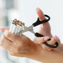 Hands cutting cigarettes with scissors